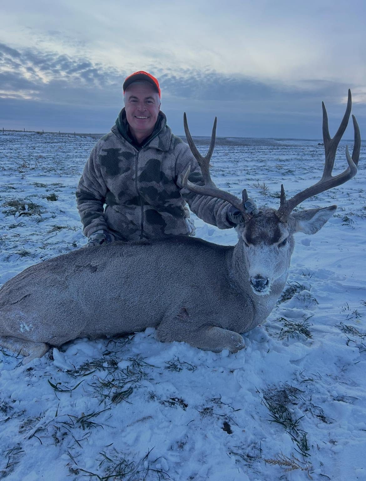 Marty Jackley with a mule deer buck in the snow