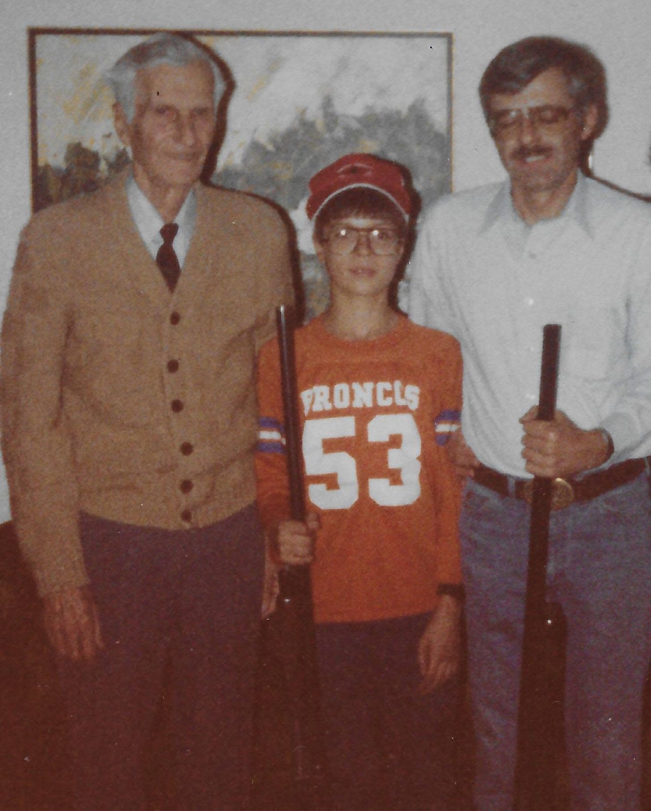Throwback photo of a young hunter and two older hunters, each holding a shotgun
